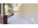 Covered porch with brick columns, ceiling fan, and outdoor views is perfect for entertaining at 5590 Elk Knob Ct, Denver, NC 28037