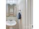 Stylish powder room with pedestal sink, framed mirror, and modern lighting at 5590 Elk Knob Ct, Denver, NC 28037