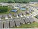 An aerial view of a neighborhood featuring manicured lawns, sidewalks, and tennis courts at 6015 Waldorf Ave, Monroe, NC 28110
