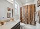 Bathroom featuring a single vanity, toilet, and shower with patterned curtain at 6015 Waldorf Ave, Monroe, NC 28110