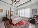 Spacious bedroom featuring a four-poster bed, ornate rug, and coffered ceilings with fan at 6015 Waldorf Ave, Monroe, NC 28110