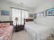Bright bedroom with two beds, side table, and white curtains for privacy at 6015 Waldorf Ave, Monroe, NC 28110