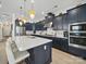 Modern kitchen with blue cabinets, stainless steel appliances, marble backsplash, and gold accents at 6015 Waldorf Ave, Monroe, NC 28110