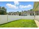 A view of a green backyard with a white fence and neighboring houses, providing a sense of community at 6333 Cory Bret Ln, Charlotte, NC 28278