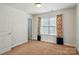 Bedroom with neutral carpet, walls, and window, accentuated by colorful floral curtains at 6333 Cory Bret Ln, Charlotte, NC 28278