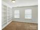 Bonus room has neutral carpet and a built-in bookcase on one wall, next to a window at 6333 Cory Bret Ln, Charlotte, NC 28278