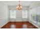 Bright dining room with hardwood floors, chandelier, and large windows providing ample natural light at 6333 Cory Bret Ln, Charlotte, NC 28278