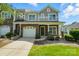 Charming townhome featuring a stone facade, attached garage, and well-maintained front lawn at 6333 Cory Bret Ln, Charlotte, NC 28278