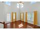 Bright living room featuring high ceilings, hardwood floors, and large windows dressed with patterned curtains at 6333 Cory Bret Ln, Charlotte, NC 28278