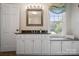 Well-lit bathroom featuring white cabinets, granite countertop, and window providing natural light at 6745 Wheeler Dr, Charlotte, NC 28211