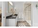 Well-lit bathroom featuring a granite vanity, a framed mirror, and a glass-enclosed shower stall at 6745 Wheeler Dr, Charlotte, NC 28211