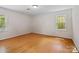 Clean and spacious bedroom with hardwood floors and natural light from two windows at 6745 Wheeler Dr, Charlotte, NC 28211