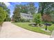 Charming two-story home with a well-manicured lawn and a long driveway leading to the house at 6745 Wheeler Dr, Charlotte, NC 28211