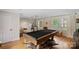 Spacious game room offering a pool table, natural light from multiple windows, and elegant hardwood floors at 6745 Wheeler Dr, Charlotte, NC 28211