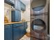 Charming laundry room boasts blue cabinets, butcher block countertops, and modern washer/dryer units at 6745 Wheeler Dr, Charlotte, NC 28211