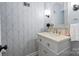Stylish powder room featuring patterned wallpaper, a vanity with decorative hardware, and modern fixtures at 6745 Wheeler Dr, Charlotte, NC 28211