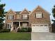Charming two-story brick home featuring a manicured lawn and an attached two-car garage at 707 Five Leaf Ln, Waxhaw, NC 28173