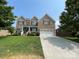 Beautiful two-story brick home with a two-car garage, lovely landscaping, and a inviting front porch at 707 Five Leaf Ln, Waxhaw, NC 28173