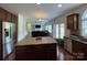 Open kitchen with island, stainless appliances, and hardwood floors overlooks living area at 707 Five Leaf Ln, Waxhaw, NC 28173