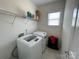 Bright laundry room featuring tile floors, wire shelving, a window and front load washer and dryer at 707 Five Leaf Ln, Waxhaw, NC 28173