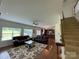 Open-concept living room flows into kitchen with staircase, hardwood floors and natural light at 707 Five Leaf Ln, Waxhaw, NC 28173