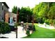Serene backyard featuring a hot tub, outdoor kitchen, dining area, and lush landscaping at 7170 Kenyon Dr, Denver, NC 28037