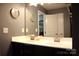 A bright bathroom features dual sinks with chrome faucets, white countertops and black cabinets at 7170 Kenyon Dr, Denver, NC 28037
