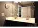 Bathroom featuring double vanity, black cabinets, framed mirror, and neutral color scheme at 7170 Kenyon Dr, Denver, NC 28037