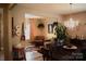 Elegant dining room featuring a chandelier, hardwood floors, and an open layout to the living area at 7170 Kenyon Dr, Denver, NC 28037