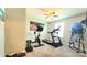 Well-lit exercise room with multiple exercise bikes, treadmill, and a colorful city picture at 7170 Kenyon Dr, Denver, NC 28037