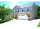 Charming two-story home boasts a spacious garage, beautifully landscaped yard, and inviting curb appeal at 7170 Kenyon Dr, Denver, NC 28037