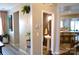Hallway with view into half bath and kitchen, light wood flooring, and neutral wall colors at 7170 Kenyon Dr, Denver, NC 28037