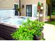 Backyard view featuring a bubbling hot tub surrounded by lush greenery and decorative plants at 7170 Kenyon Dr, Denver, NC 28037