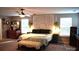Spacious main bedroom with decorative headboard, bench, ceiling fan, and neutral walls at 7170 Kenyon Dr, Denver, NC 28037
