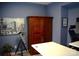 Home office with a large wardrobe, a telescope, wood-look flooring and blue walls at 7170 Kenyon Dr, Denver, NC 28037