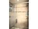 Tiled shower featuring a glass door, double shower heads, and built-in shelving at 7170 Kenyon Dr, Denver, NC 28037