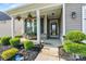 Charming front porch with stone accents, hanging plants, and a welcoming entrance at 7809 Creek Park Dr, Denver, NC 28037