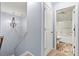 Hallway with chandelier lighting leading to an inviting bathroom with a shower and toilet at 7809 Creek Park Dr, Denver, NC 28037