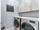 Functional laundry area features a washer, dryer, white countertops, and ample cabinet space at 7809 Creek Park Dr, Denver, NC 28037