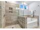 Elegant shower with light gray tile surround, with glass enclosure and a separate soaking tub nearby at 7809 Creek Park Dr, Denver, NC 28037