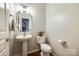 Cozy half bathroom featuring a pedestal sink, modern fixtures, and stylish decor at 815 Granby Dr, Fort Mill, SC 29708