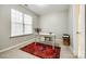 Bright room with a red patterned rug, white desk, large window, and neutral walls at 815 Granby Dr, Fort Mill, SC 29708