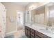 Well-lit bathroom with double vanity, large mirror, and a shower with a floral curtain at 8460 Fairgreen Ave, Waxhaw, NC 28173