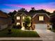 Beautiful two-story brick home with a manicured lawn and an attached two-car garage at dusk at 8460 Fairgreen Ave, Waxhaw, NC 28173