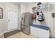 Functional mudroom with storage bench, hooks, and stainless steel refrigerator at 8460 Fairgreen Ave, Waxhaw, NC 28173
