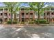 Brick townhome with balconies and mature trees creating a serene street view at 915 Northeast Dr # 15, Davidson, NC 28036