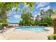 Refreshing outdoor pool surrounded by lounge chairs, lush greenery, and blue skies at 915 Northeast Dr # 15, Davidson, NC 28036