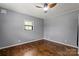 Comfortable bedroom featuring hardwood floors, a ceiling fan, and a large window for ample natural light at 935 Church St, Kings Mountain, NC 28086