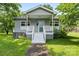 Charming home featuring a quaint porch, light gray siding, complemented by a well-maintained lawn and mature trees at 935 Church St, Kings Mountain, NC 28086