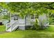 Charming home featuring a quaint porch, light gray siding, complemented by a well-maintained lawn and mature trees at 935 Church St, Kings Mountain, NC 28086